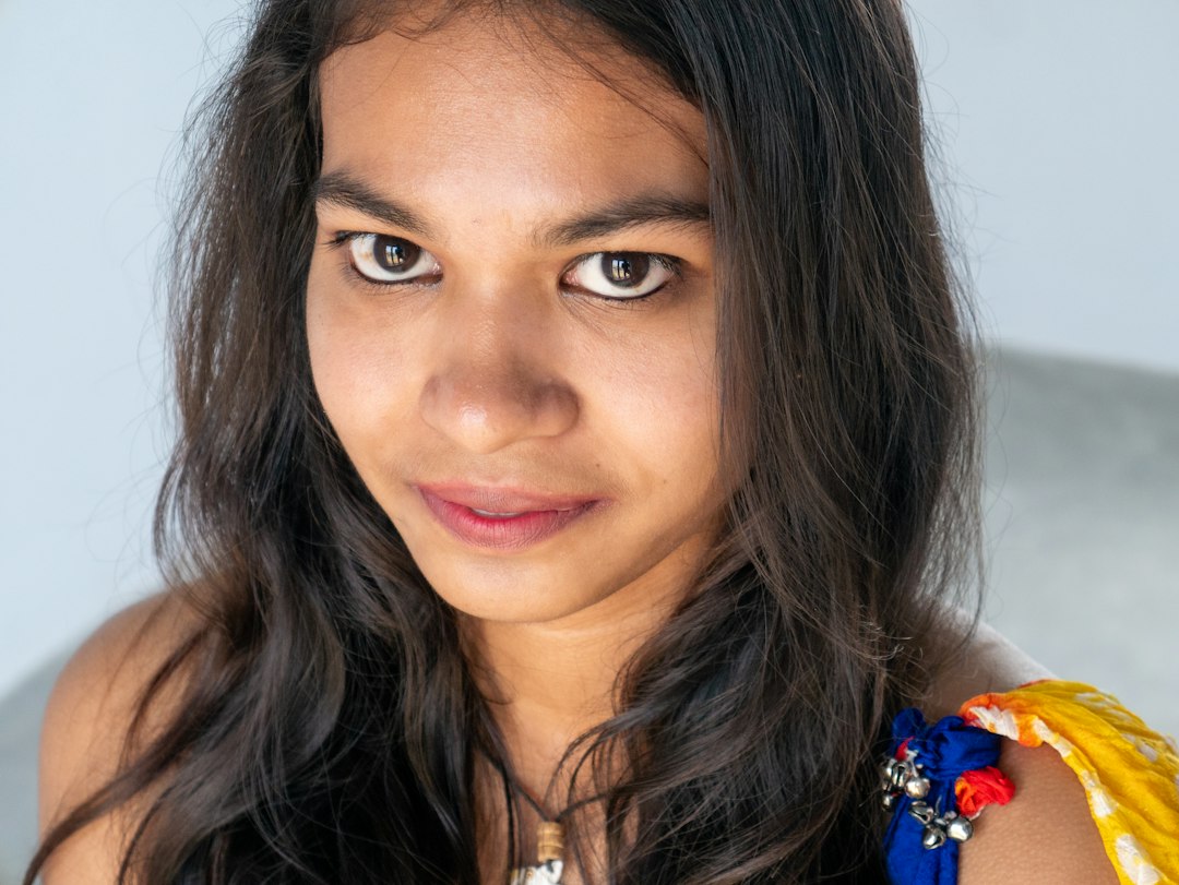 Close-up studio portrait of a young Indian woman with clear, glowing skin