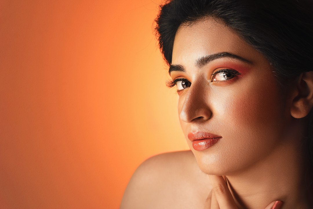 Indian woman with clear, glowing skin in a warm-lit studio portrait