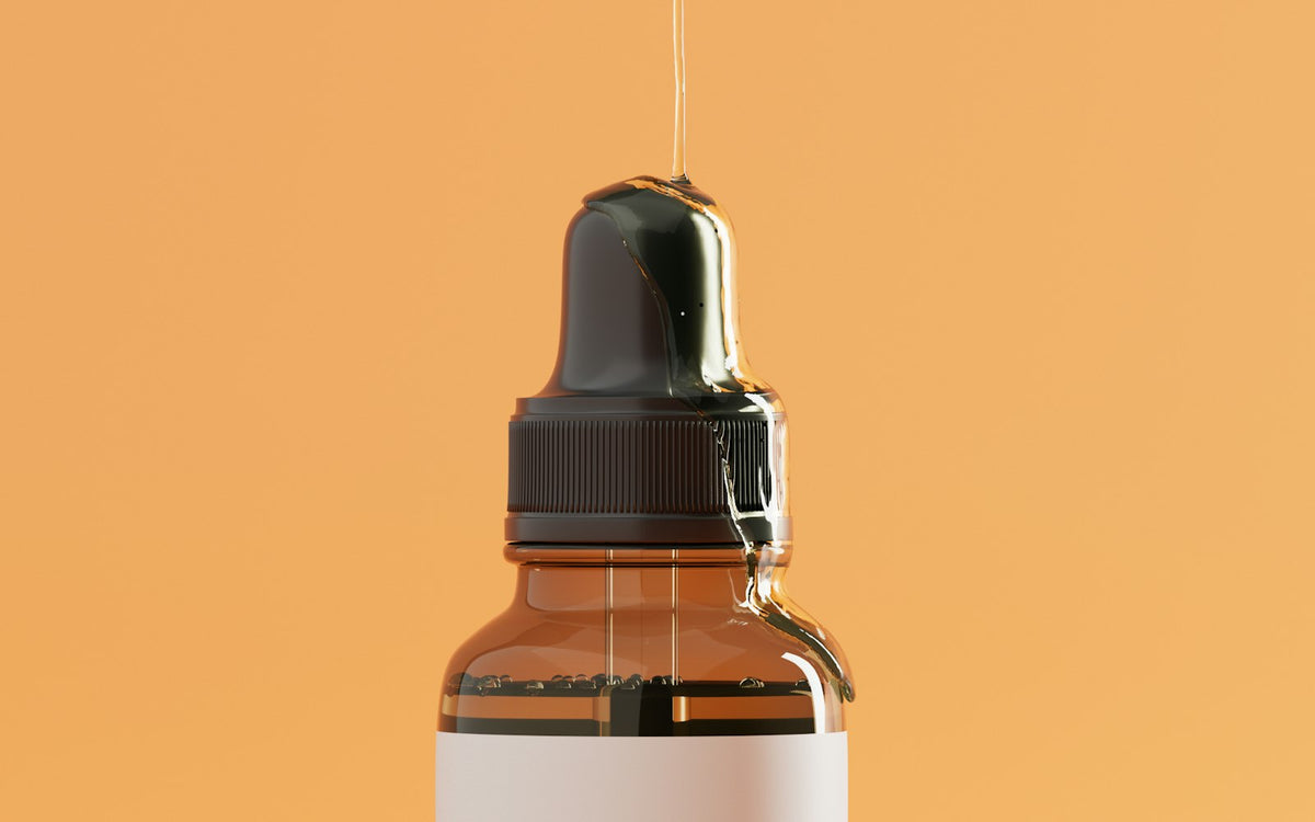 Dropper bottle of serum against an orange background