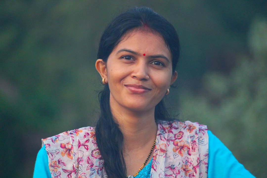 Smiling Indian woman with clear, glowing skin in soft natural outdoor light